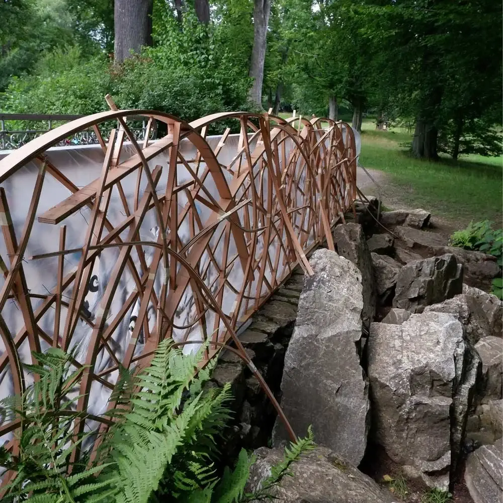 Stahlgeländer der Brücke am Schwanenteich zwischen Felsen und Farnen