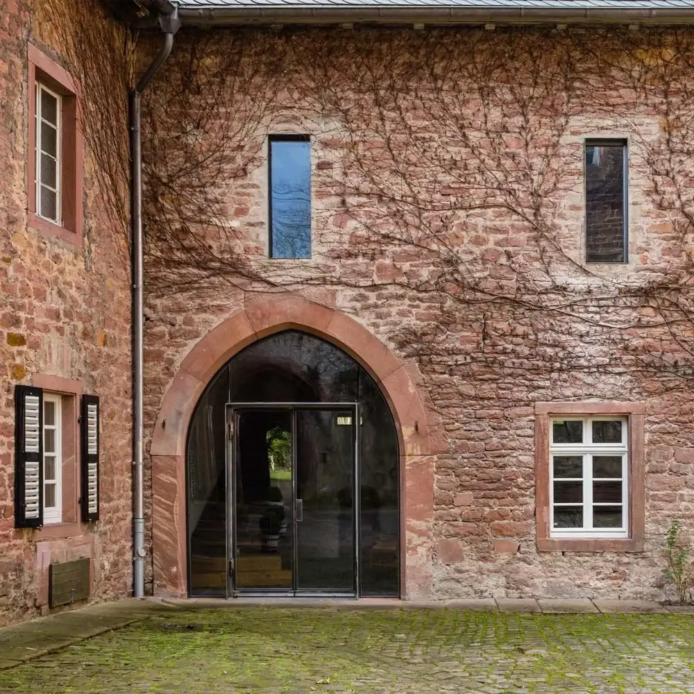Hoffassade der Mittelburg aus rotem Sandstein mit verglastem Spitzbogenportal