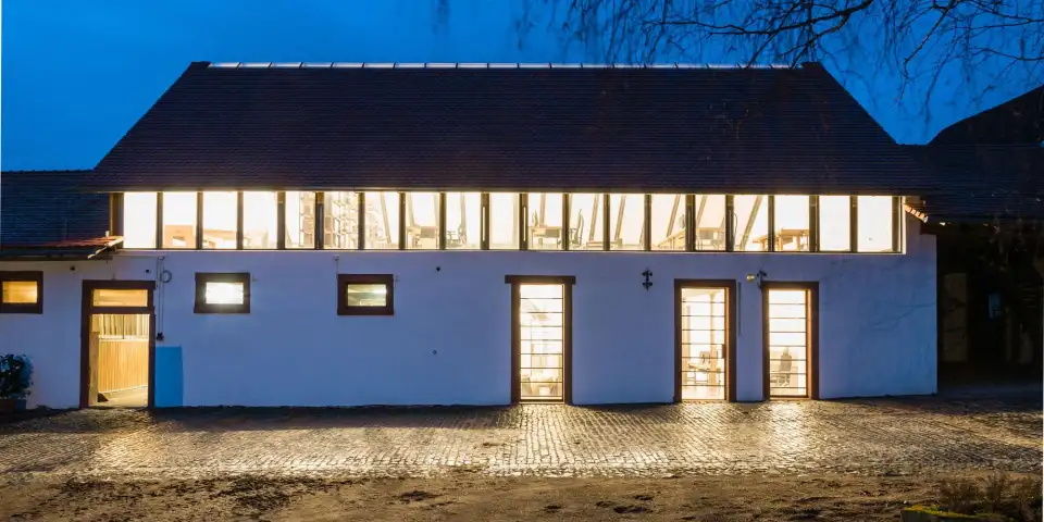 Ehemaliger Stall der Hofanlage Dilshofen am Abend, Lichtband im neuen Obergeschoss