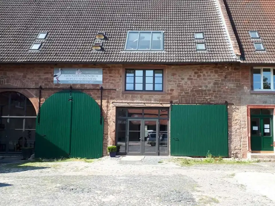 Wirtschaftsflügel des Hofguts Habitzheim mit grünen Toren